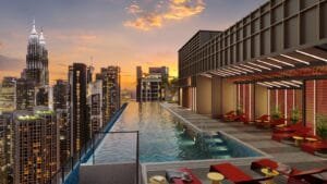 Rooftop pool deck at Phoeniz Suites @ KLCC with sunset skyline view and lounge seating area.